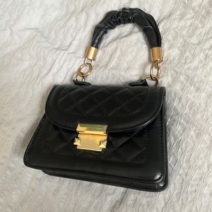 Black quilted hand bag with gold metal design